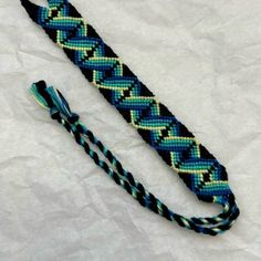 a blue and black braided lanyard on white paper