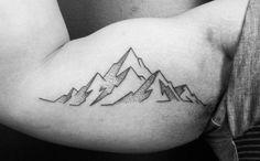 a man with a mountain tattoo on his arm