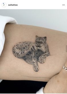 a woman's thigh with a tattoo of a cat laying on top of it