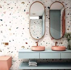 a bathroom with two sinks and mirrors on the wall