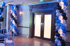 an entrance decorated with blue and black balloons