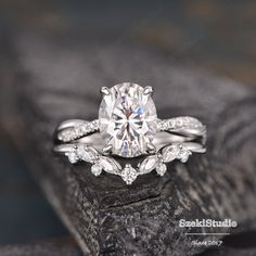 a close up view of a diamond engagement ring on a piece of wood with the stone behind it