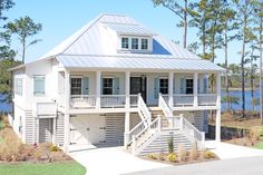 a white two story house with stairs leading up to it