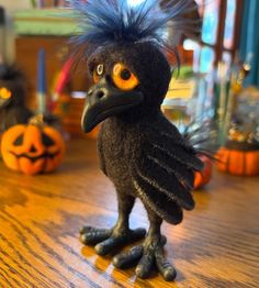 a black bird sitting on top of a wooden table