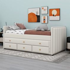 a white bed sitting on top of a wooden floor