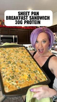 a woman with purple hair holding up a pan filled with breakfast sandwich and the words sheet pan breakfast sandwich 30g protein