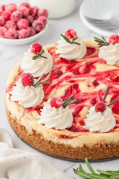 a cheesecake topped with whipped cream and raspberries on a white tablecloth