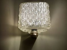 a glass light fixture on a wall in a room