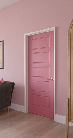 a living room with pink walls and a brown chair in front of the door that is open