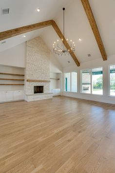 an empty living room with wood floors and exposed beams