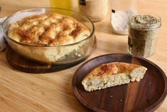 a wooden plate with a piece of pie on it next to a bowl of bread