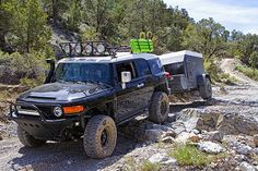 a black truck driving down a rocky road