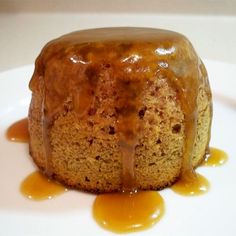 a cake with caramel drizzled on it sitting on a white plate