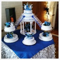 three tiered wedding cake on top of a blue and white table cloth with flowers