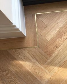 an empty room with wood flooring and white trim