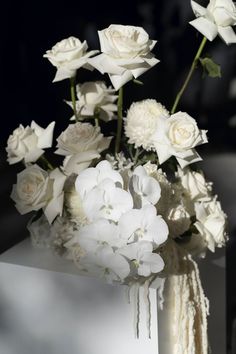 white flowers are in a vase on a table