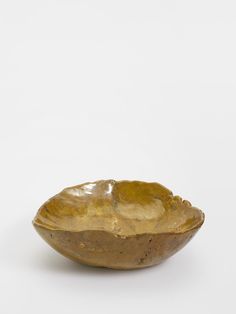 a golden bowl sitting on top of a white table