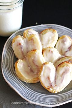 cinnamon pastry hearts on a plate next to a glass of milk