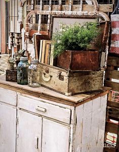 an old dresser is filled with books and plants