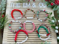 the em & co christmas bracelets are on display in front of holly wreaths