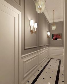 an empty hallway with white walls and black and white flooring, chandelier