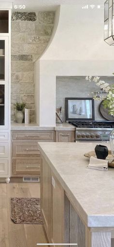 a kitchen with white cabinets and an island in front of a tv on the wall