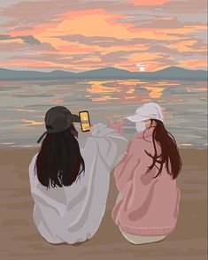 two women sitting on the beach watching the sunset