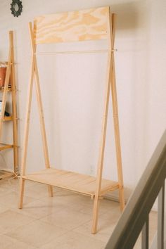 a wooden shelf sitting on top of a tiled floor next to a stair case in a room