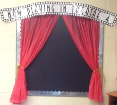 a red curtain is hanging over a black board