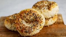 two bagels sitting on top of a wooden cutting board