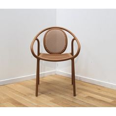 a brown chair sitting on top of a hard wood floor next to a white wall