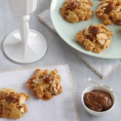 some cookies are sitting on a table next to a bowl of peanut butter