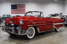 an old red car parked in a garage