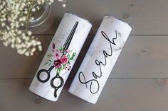 two canisters with scissors and flowers on them