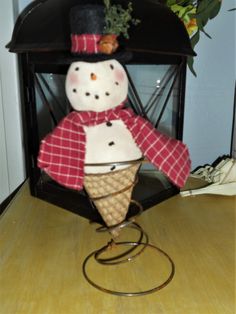 an ice cream cone with a snowman on top