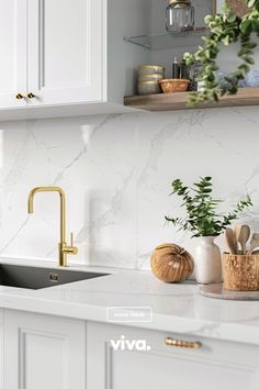 a kitchen with white cabinets and marble counter tops, gold faucet, wooden cutting board