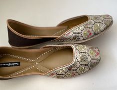 'BROWN BEAUTY' is an extraordinary jutti and is truly elegant, timeless and graceful!! Gold brocade silk base with delicate floral motifs and deep brown back. Pair it with ANY OUTFIT!! Punjabi Jutti / Khussa/ mojari / Ethnic shoes/ Women Flats/Handmade Indian Designer Women Shoes or Slippers/ Royal shoes/ traditional style Women / Wedding Shoes / Bridal Shoes SPECIFICATIONS: * Upper/Panna -Gold brocade silk fabric base with floral motifs * Back/Adda - Brown Fabric base * Lining - Leather * Paddi Meenakari Slip-on Flats For Wedding, Wedding Meenakari Slip-on Flats, Meenakari Wedding Flats, Traditional Open Toe Wedding Shoes For Festive Occasion, Traditional Open Toe Wedding Shoes, Festive Cut Dana Flats For Wedding, Festive Wedding Flats With Cut Dana, Transitional Slip-on Wedding Shoes, Transitional Wedding Slip-on Shoes