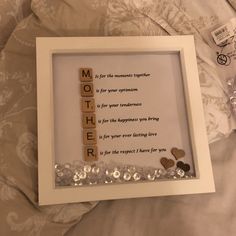 a scrabble frame with the word mother spelled in wooden letters and hearts on it