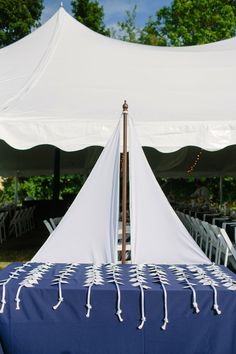 a sail boat made out of rope sitting on top of a blue and white table cloth