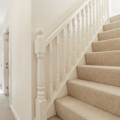 there is a white stair case next to the carpeted stairs