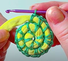 someone is crocheting an ornament on a piece of yarn with a knitting needle