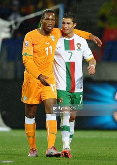 two soccer players standing next to each other on a field