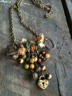 a close up of a necklace on a wooden surface with beads and charms hanging from it