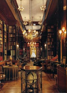 an old library with chandeliers and bookshelves