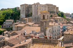 an aerial view of old buildings in a city with stone roofs and yellow tiled roofs