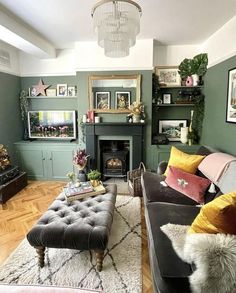 a living room filled with furniture and a fire place under a chandelier in front of a fireplace