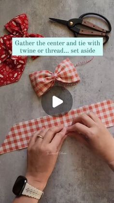 someone is making a bow tie with red and white gingham fabric on the table