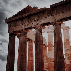 the ruins of an ancient greek temple against a cloudy sky