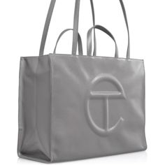 The Iconic Unisex Shopping Bag Is An Everyday Bag For Everyone. Featuring A Double Strap (Handles And Cross-Body Straps), Embossed Logo, A Main Compartment With Magnetic Snap Closure, Internal Laptop-Sized Compartment With Zipper Closure In Back And Additional Internal Pocket In Front. Made From Faux Leather And Twill Lining. Bag Is Packaged In A Drawstring Bag With Screen-Printed Logo. Large Fits A Long Weekend And Is The Ultimate Carry-On. *Model Is 5'9" Tall. Materials: 50% Polyurethane, 50% Evening Bag With Logo In Tan, Tan Evening Bag With Logo, Tan Evening Bags With Logo, Telfar Bags, Body Straps, Logo A, Everyday Bag, Long Weekend, Medium Bags