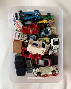 a plastic container filled with assorted toy cars